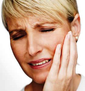 A woman in pain holding her jaw